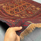 Handwoven 3.10x4.3 antique Afghan rug held in hands showing tribal wool weave and dark red tones
