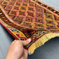 Handwoven 2.5x4.3 Turkish Afghan runner rug held in hands showing red, green and gold tribal patterns