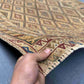 Handmade 3.2x4.3 Turkish Afghan kilim rug held in hands, showing tribal wool weave in beige, red, and blue