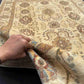 Authentic handmade ivory floral Chobi carpet 5x7 ft shown in hands – soft beige wool Persian-style carpet.