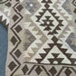Folded handmade kilim rug in beige and brown tones