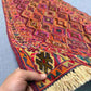 Handheld view of 2.9x9.3 Turkish handmade kilim runner with tribal pattern