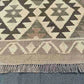 Close-up of knotted pattern on area rug – beige and brown geometric design.
