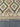 Close-up of knotted pattern on area rug – beige and brown geometric design.