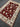 Large red Oriental rug laid flat on wooden floor – side angle