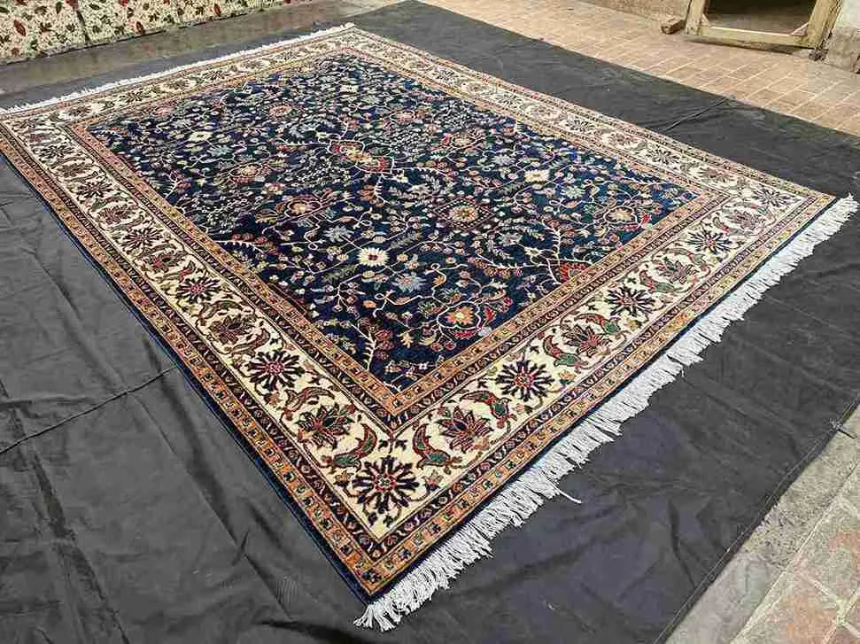 Wide-angle view of Persian Chobi rug laid out on wooden floor