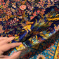 Luxury silk rug with floral and deer motifs held in hand for detail