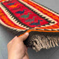 Handmade multicolor Turkish Kilim rug in red and orange tones held in hands – front tribal wool flatweave.