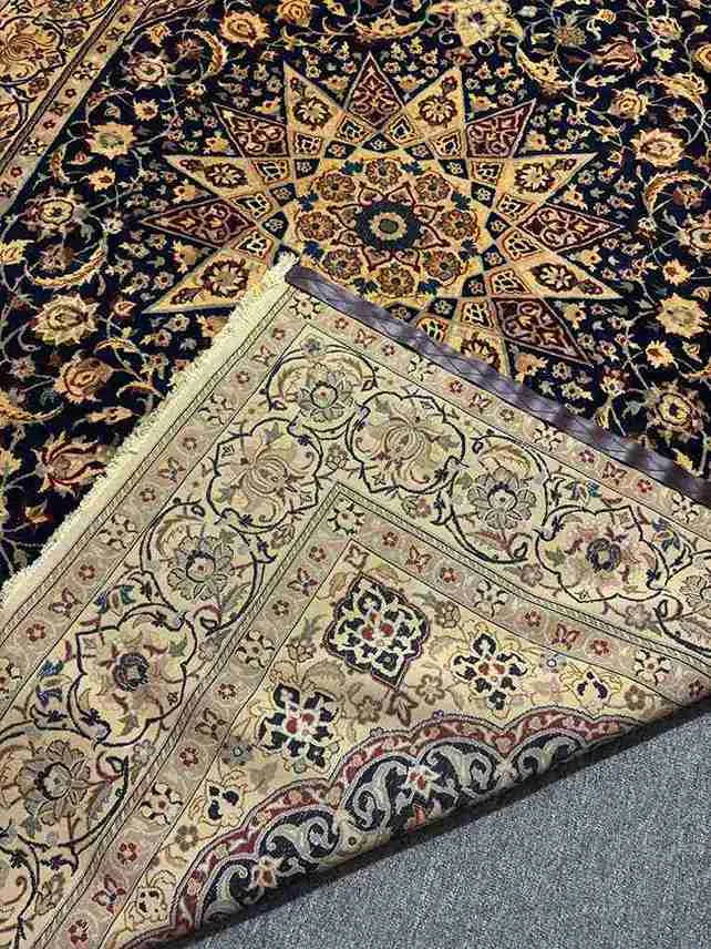 Folded Persian Nain rug showing thickness and texture