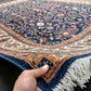 Handmade navy blue Chobi rug shown in hands – front view of wool carpet