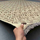 Handmade Turkish Kilim rug held in hands – front view showing earthy beige and brown geometric flatweave.