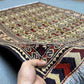 Handmade Oriental wool rug in hand with floral & tribal design