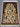 Oriental handmade silk rug on floor showing full layout and pattern.