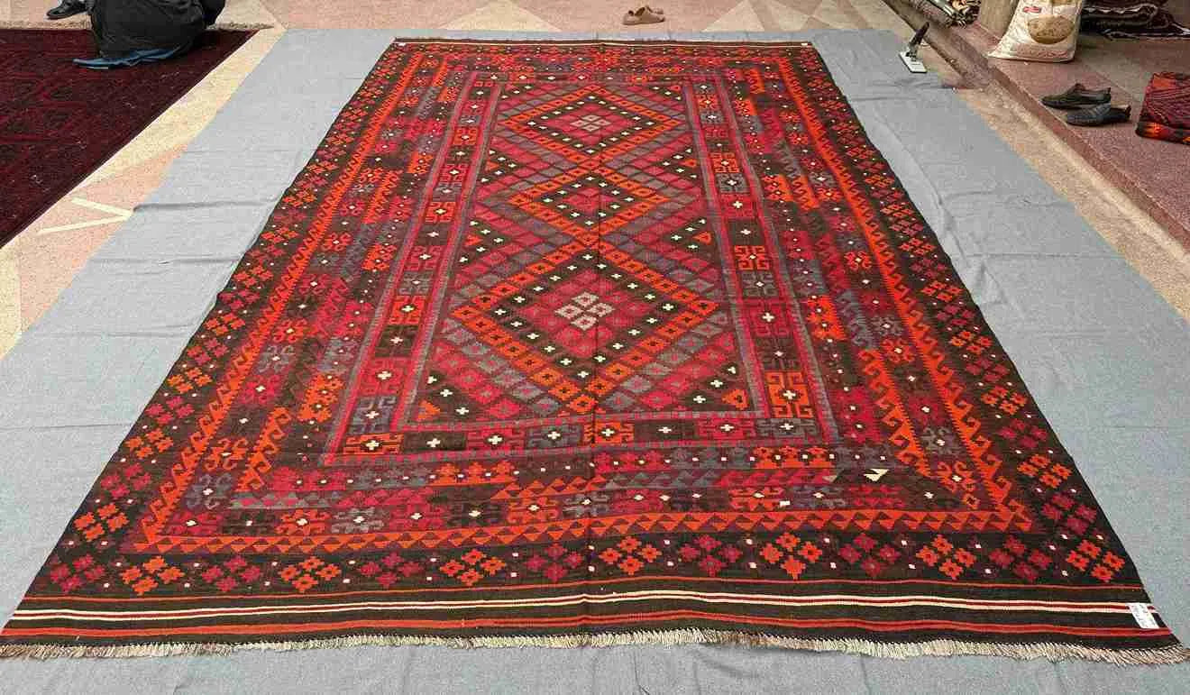 Large oriental Turkish rug with tribal design laid on floor – 8x12 wool flatweave Kilim.
