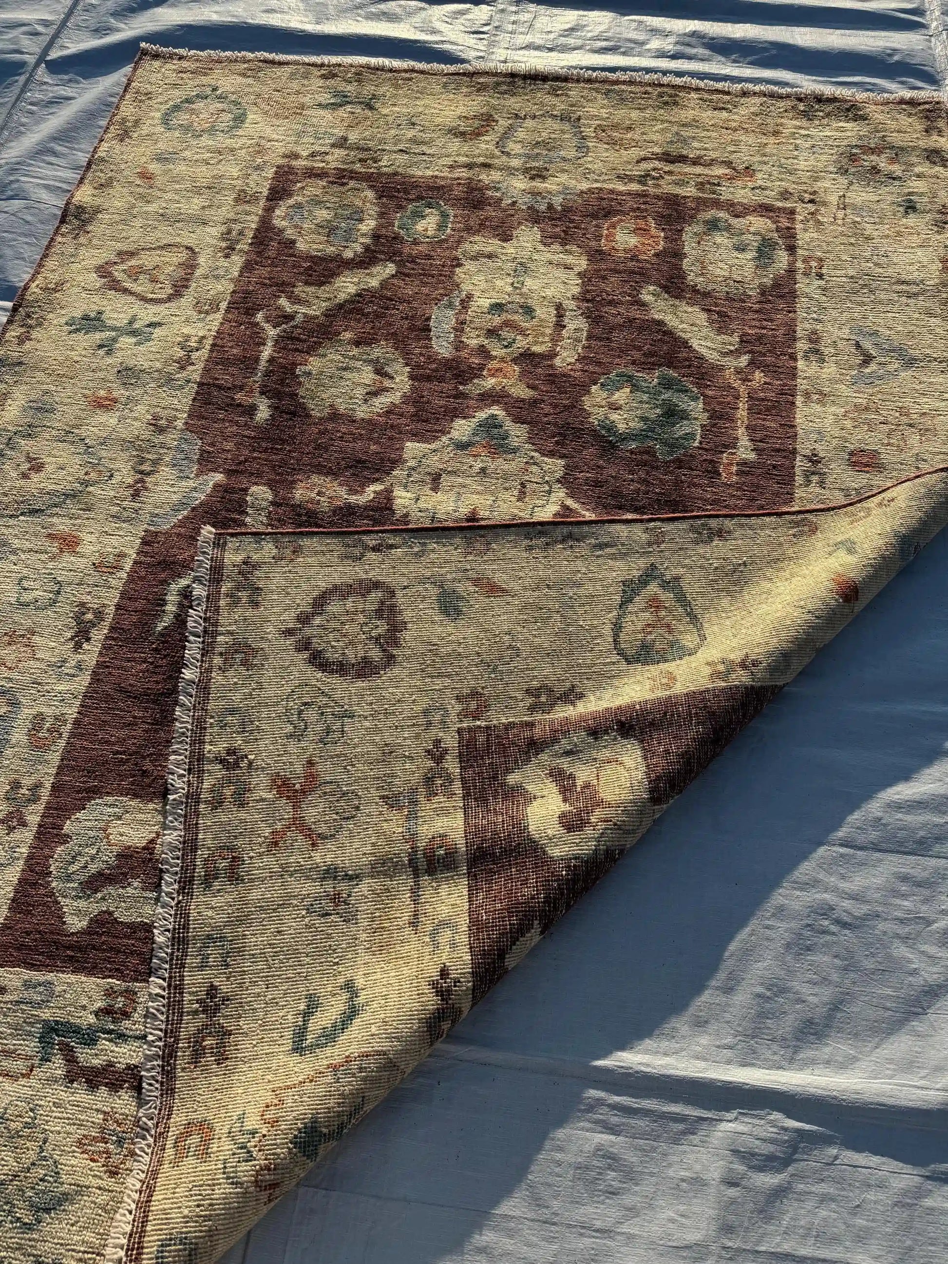  Side view of folded handmade Oushak rug 5x7 ft showing handwoven texture