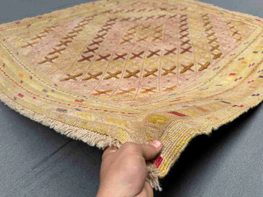 Handmade pastel Persian Afghan kilim rug in hand showing fine wool weave