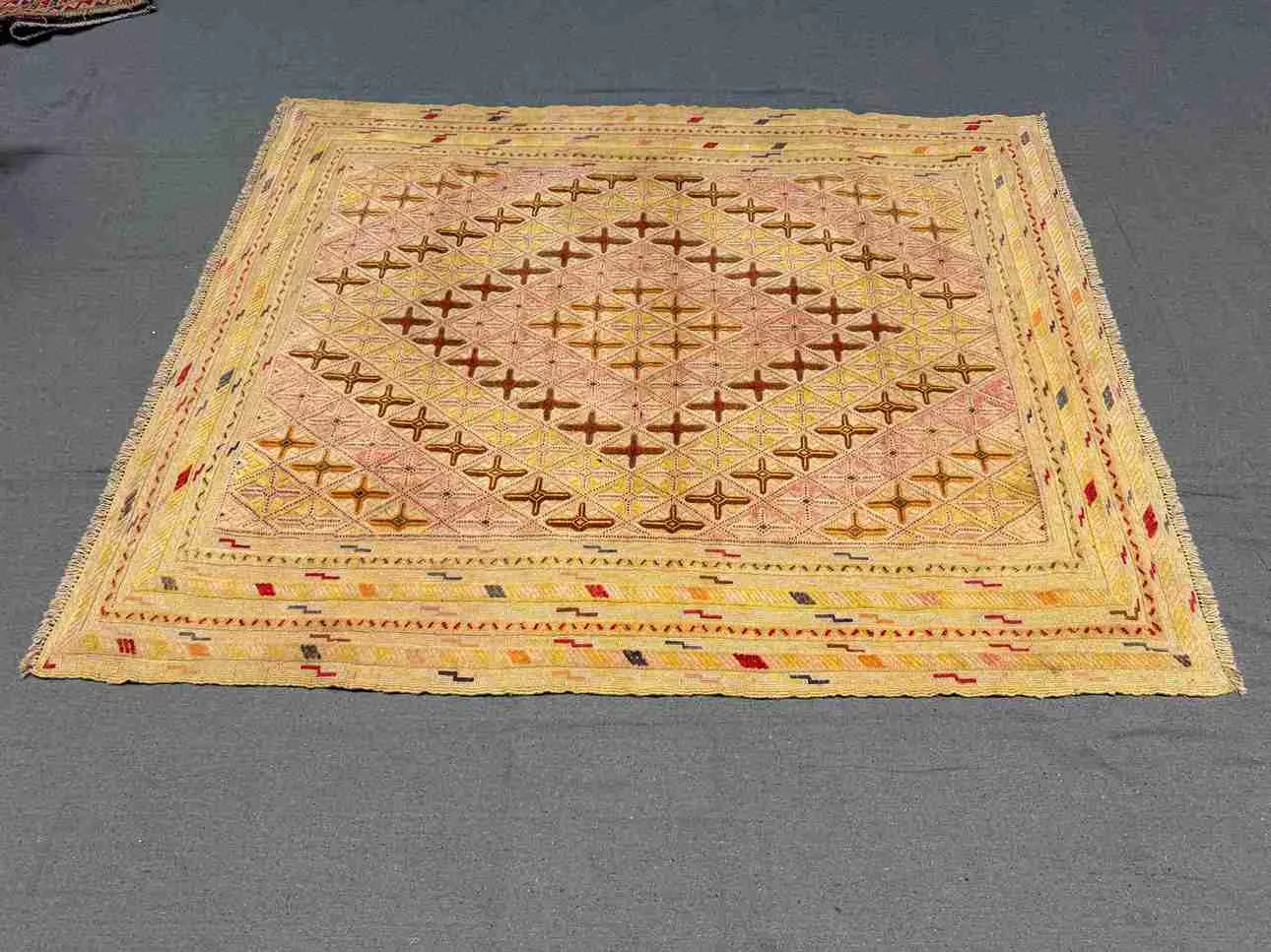 Oriental-style pastel tribal rug in bedroom with wooden floor