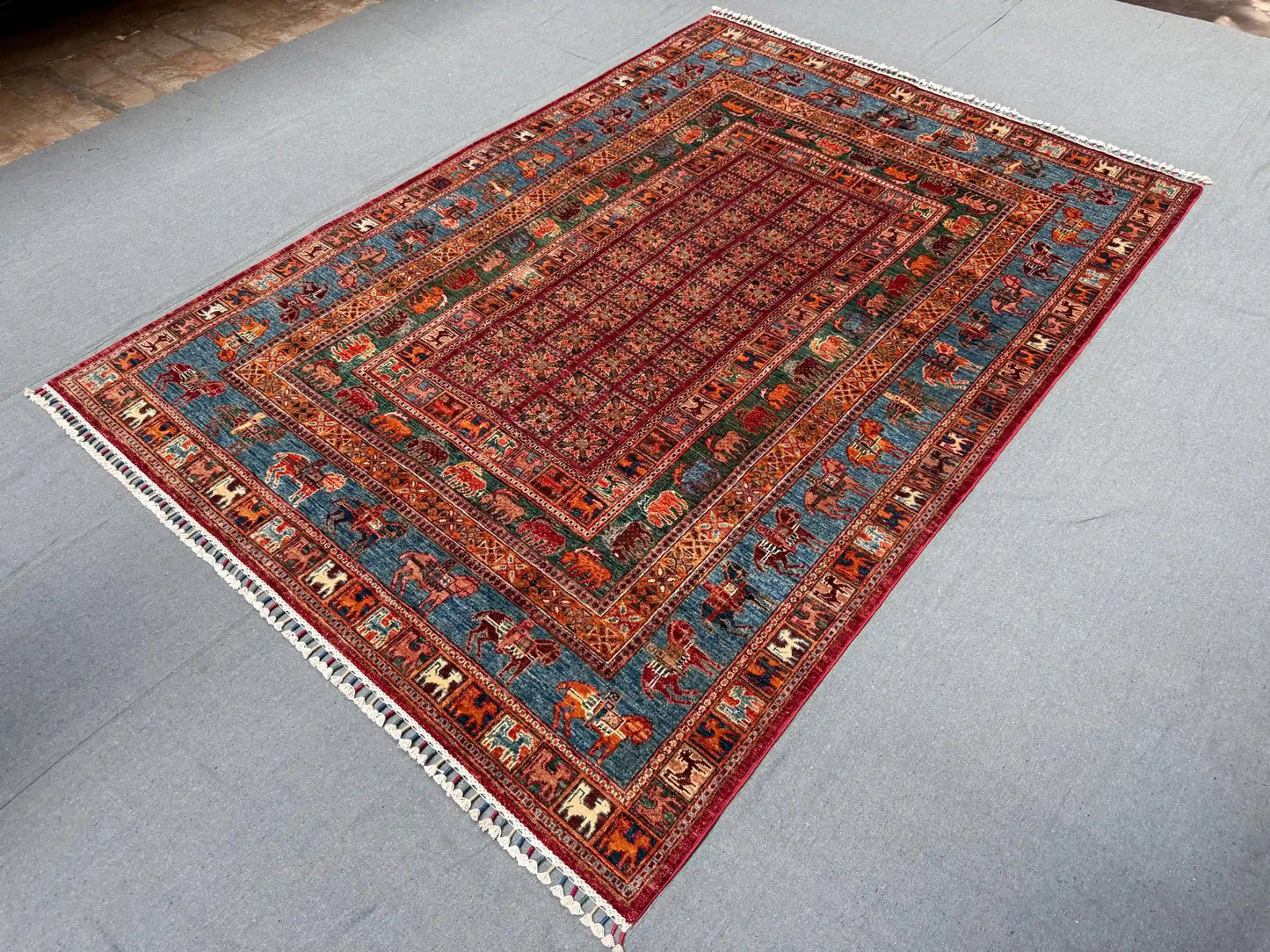 Pazyryk rug styled in living room setting with red and blue tones
