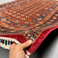 Authentic handmade Pazyryk rug shown in hands – red and blue tribal wool carpet