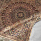 Folded Persian silk rug showcasing fabric softness and texture