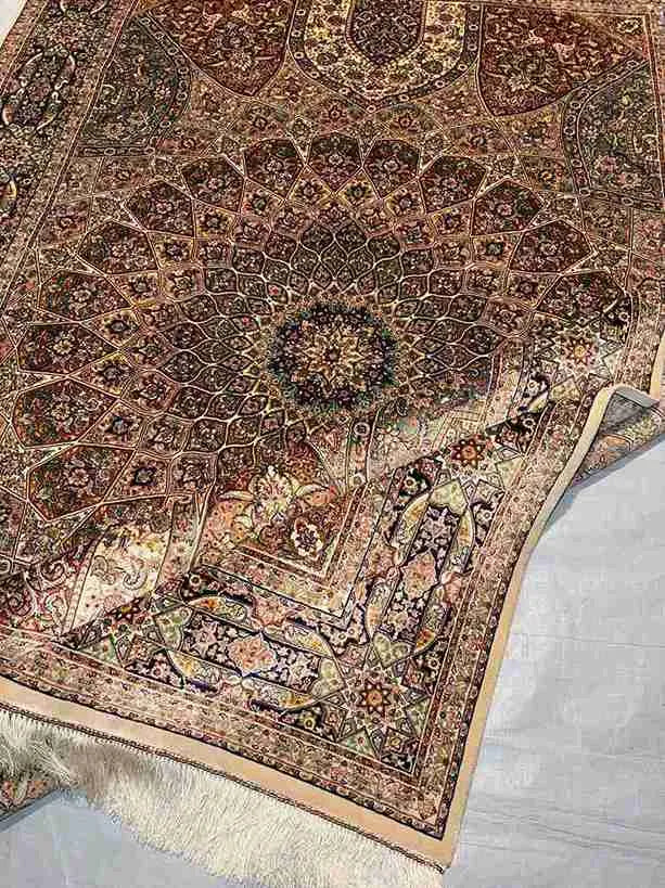 Folded Persian silk rug showcasing fabric softness and texture