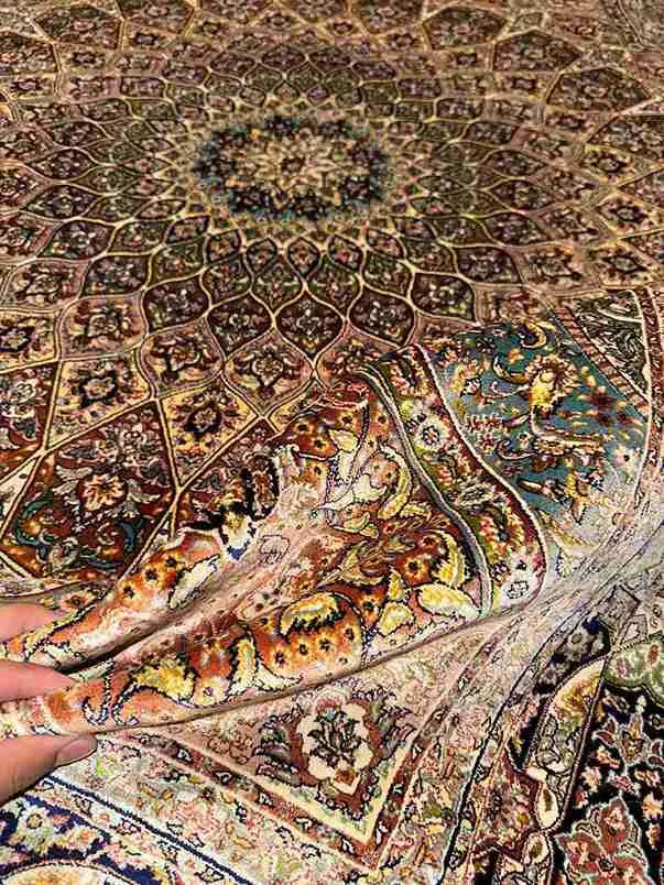 Handmade Persian Silk Rug 5x7 ft held to show fabric quality