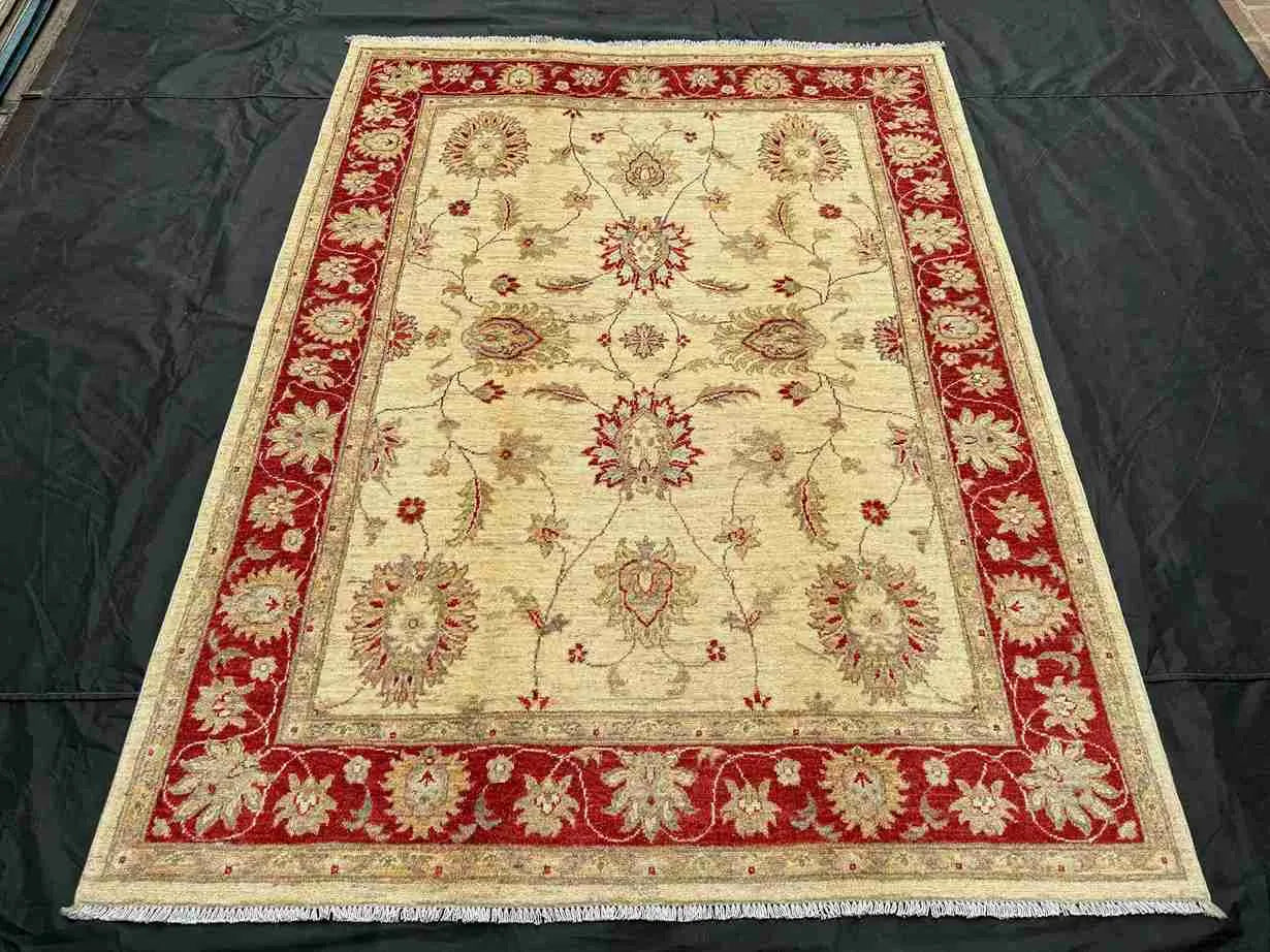 Persian-style handwoven red and cream rug placed on wood floor