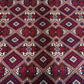 Close-up of red and beige Afghan wool silk rug with geometric pattern