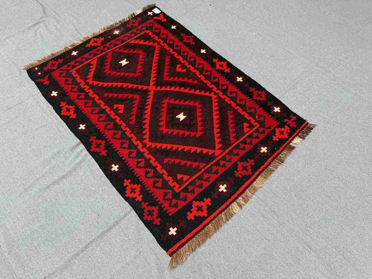 Styled floor display of red and black Kilim rug – Turkish handwoven wool area rug