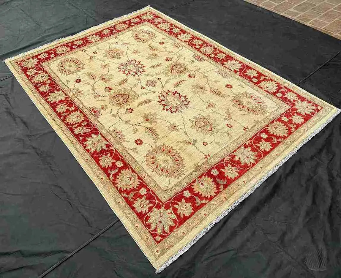 Red and cream Chobi wool rug styled in living room decor