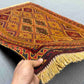 Handmade Persian Afghan kilim rug in hand showing wool weave texture