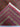 Folded view of red and green Turkmen wool rug with knotted detail