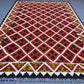 Red 5x7 kilim rug placed on floor in living room – tribal wool decor
