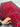 Close-up view of 3x6 ft red handmade runner rug held to show wool texture and tribal knots.