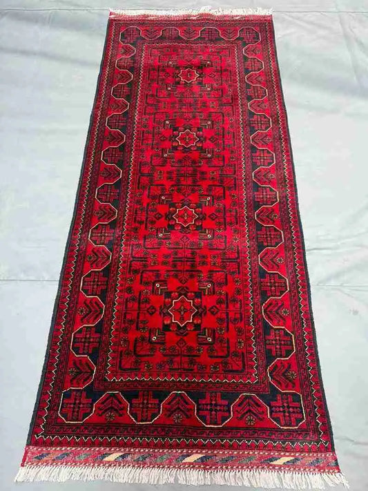 Red tribal runner rug placed in hallway setting—perfect for narrow spaces.
