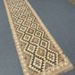 Reversible flatweave Kilim carpet used in hallway setting – brown and beige tones.