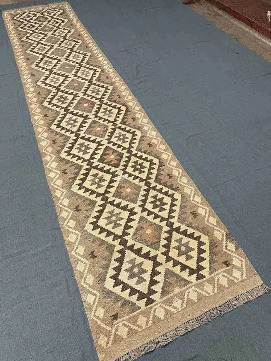 Reversible flatweave Kilim carpet used in hallway setting – brown and beige tones.