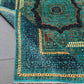 Folded wool Mamluk rug in green and gold for texture inspection