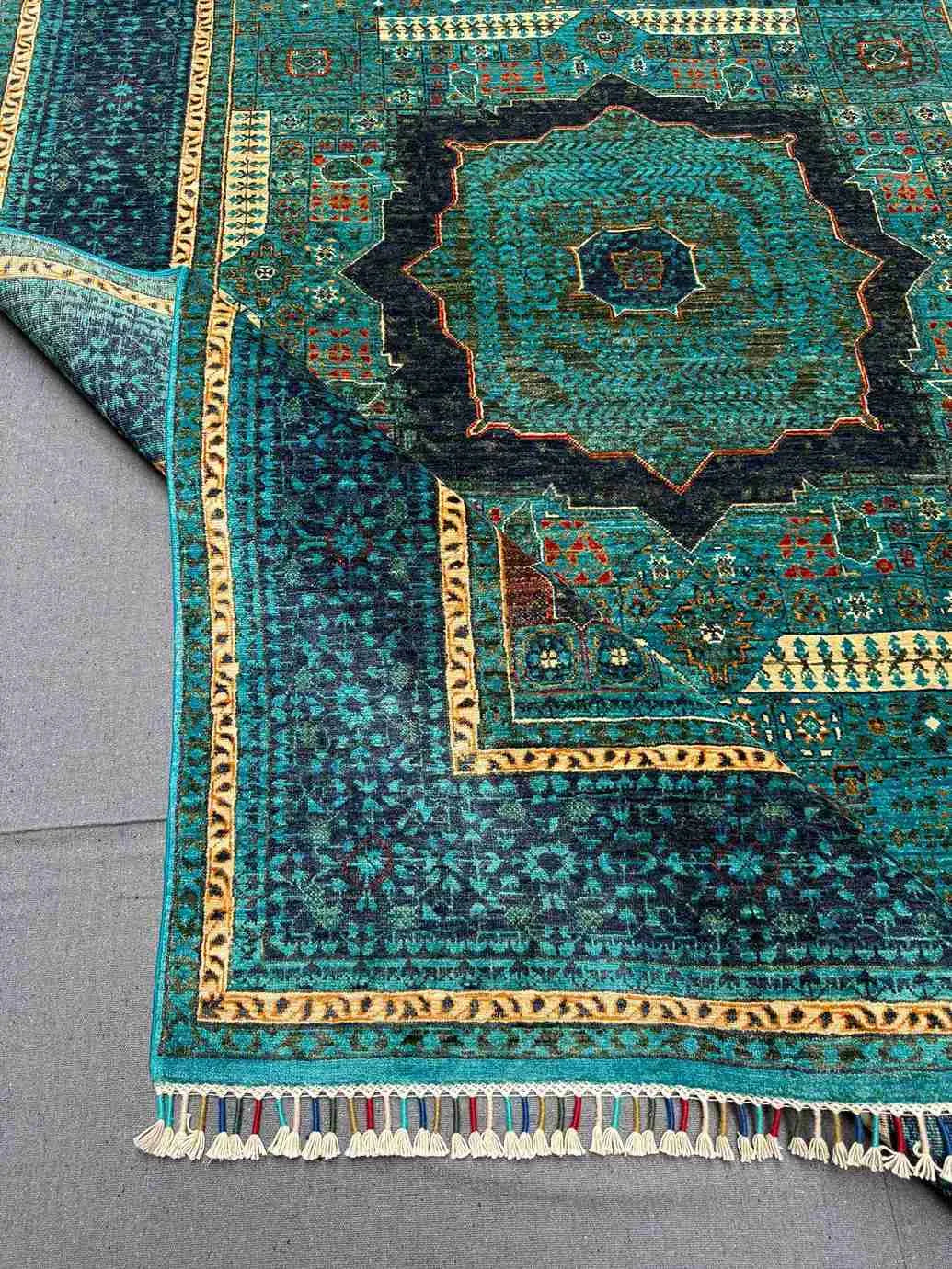 Folded wool Mamluk rug in green and gold for texture inspection