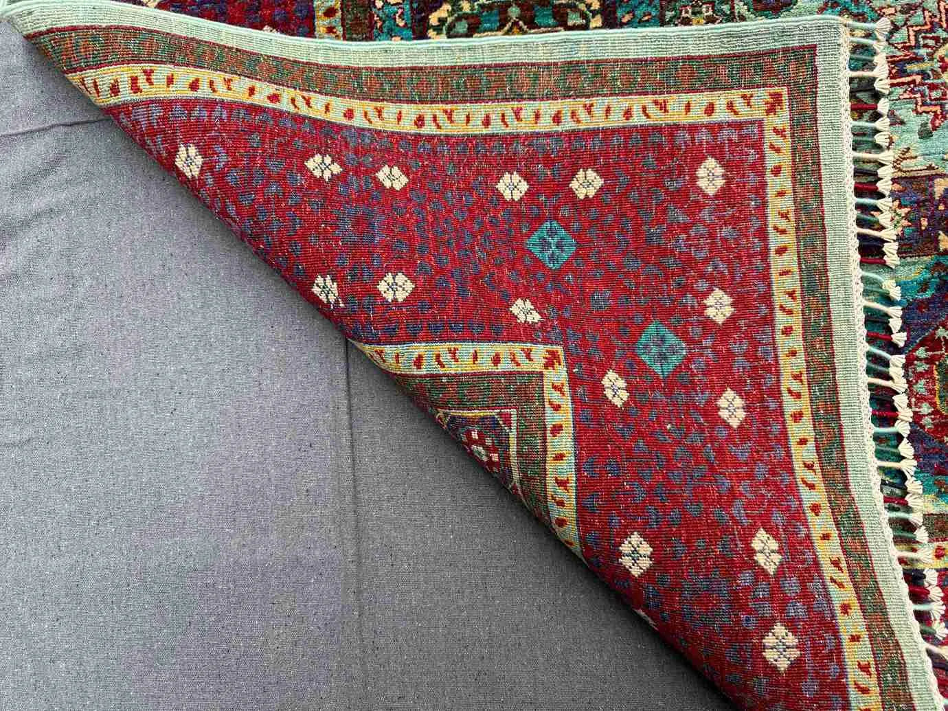 Backside of folded 6x8 red and teal Mamluk wool & silk rug