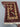 Reverse side texture of folded hand-knotted 3x4 red and cream Afghan rug
