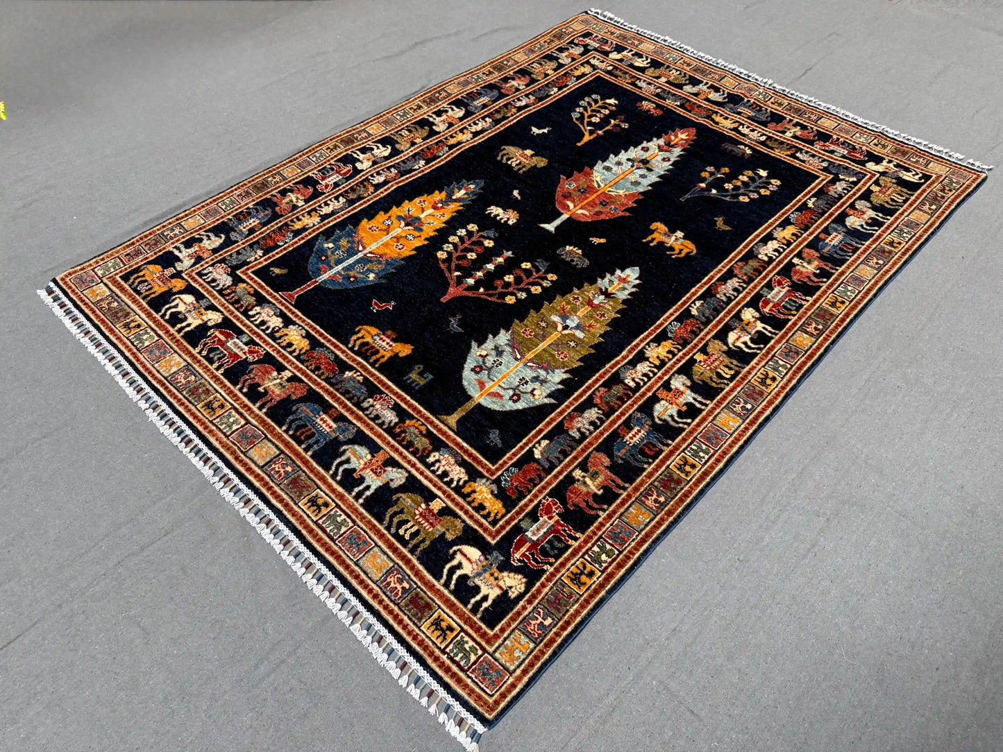 Side angle of handmade Tree of Life rug on hardwood floor