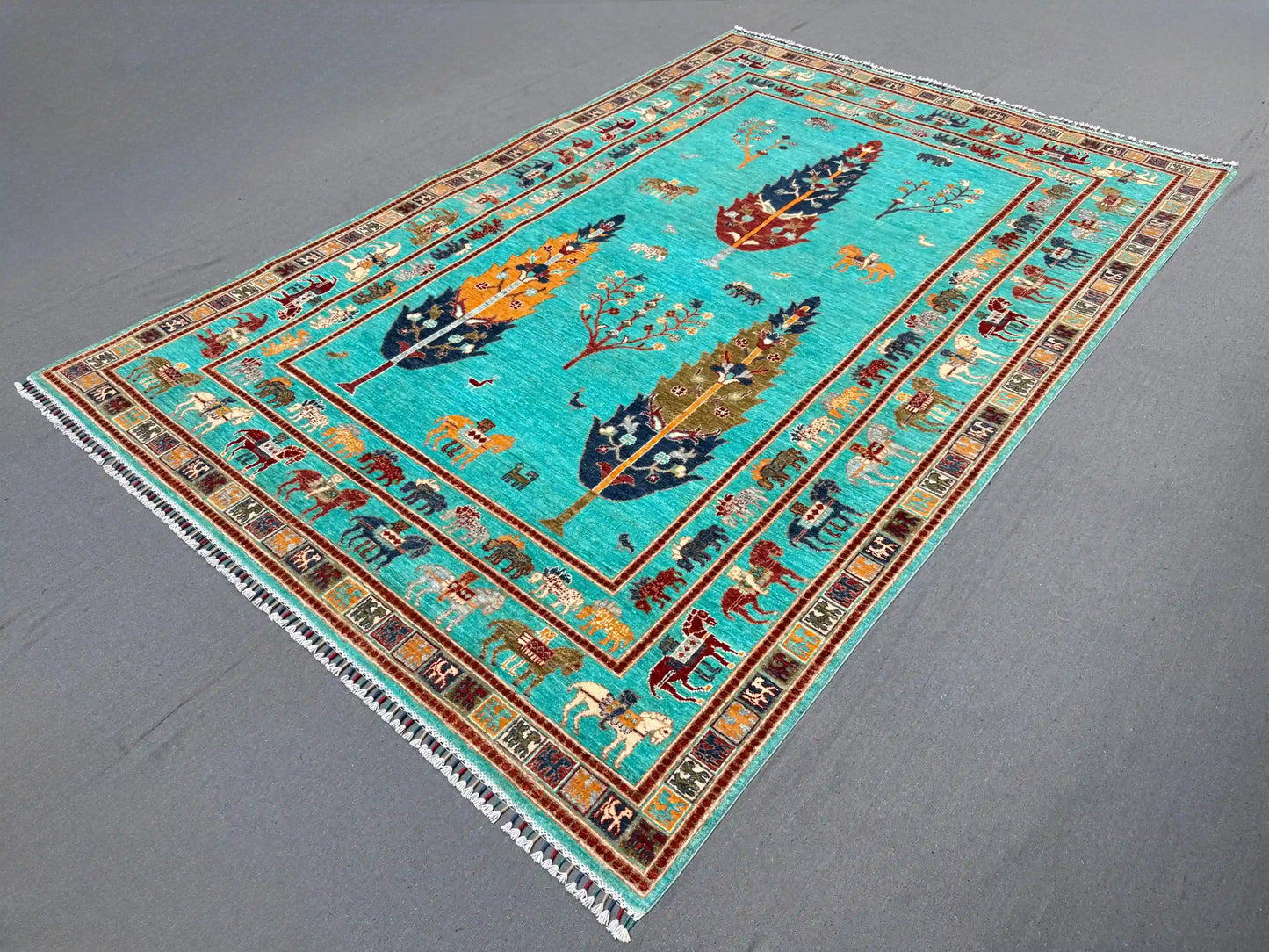 Side angle of turquoise Tree of Life wool rug on floor