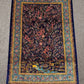 Persian silk rug with garden and deer motifs displayed in room