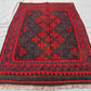 Vintage red Kilim rug displayed on floor – handmade small wool rug for rustic or boho decor.