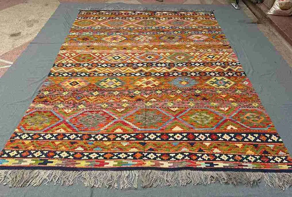 Floor scene with traditional handwoven Khorjin Kilim rug – bold colors and Persian-style flatweave.