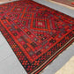 Traditional Turkish Kilim rug in red and black on wooden floor – large 8x12 handmade wool area carpet.