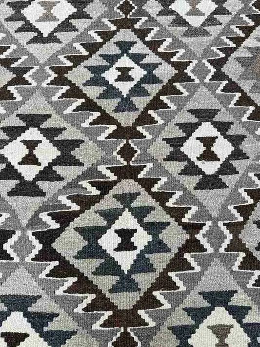 Close-up texture of traditional Turkish Kilim pattern – knotted wool rug in warm earth tones.