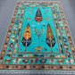 Full view of Tree of Life wool rug in turquoise blue on floor