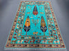Full view of Tree of Life wool rug in turquoise blue on floor